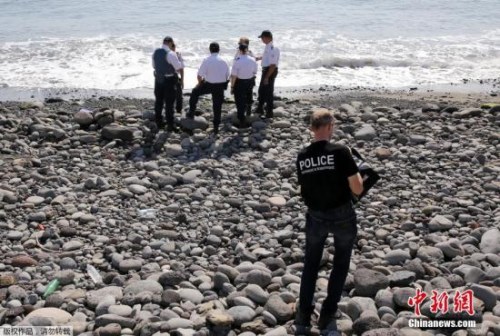 當?shù)貢r間8月2日，法屬留尼旺首府圣但尼附近的一處海灘上，警員正在現(xiàn)場對金屬殘片進行勘察。